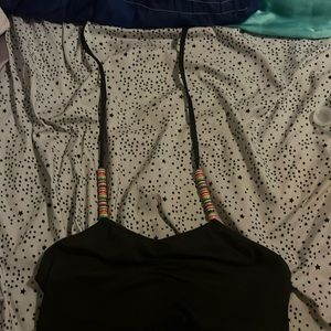 A black cropped top that has beads on the strings.